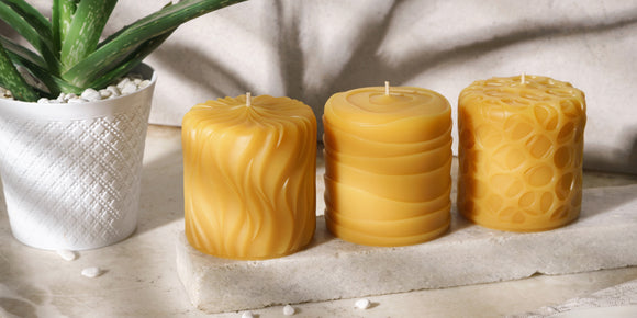 three decorative beeswax candle pillars